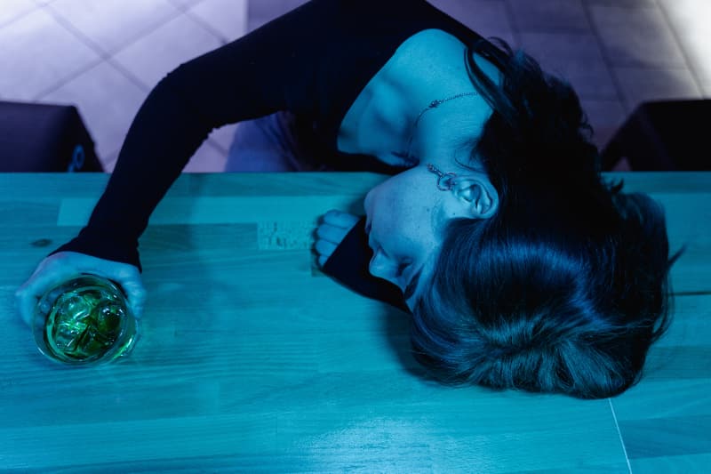 A woman laying on the ground in a dark room.